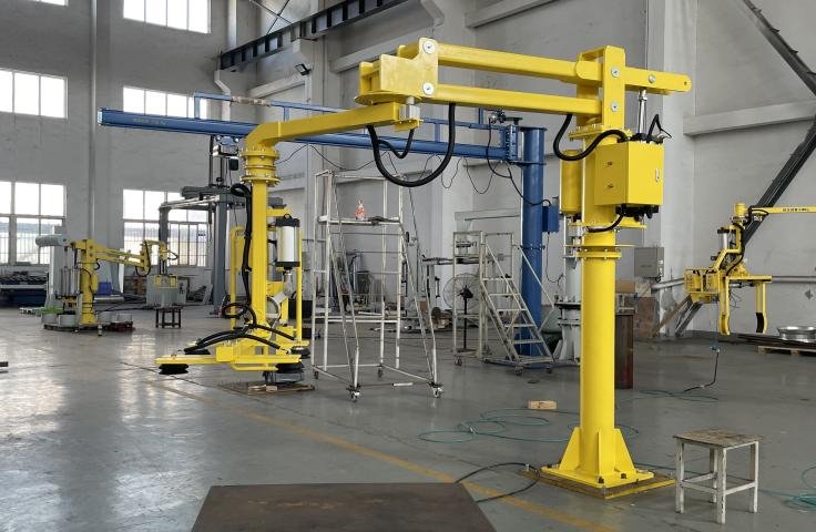 Yellow industrial robotic arms in a factory setting.